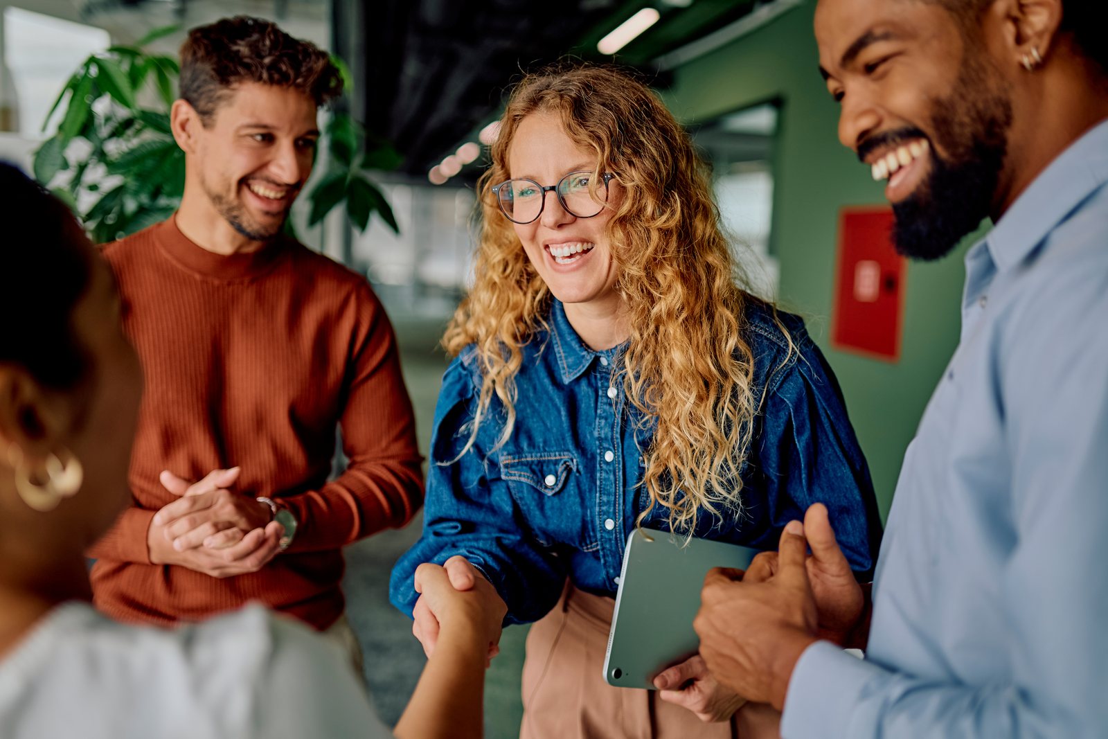 Équipe diversifiée en discussion chaleureuse dans un bureau lumineux